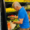 An image of a man in front of a produce cooler putting a vegetable in a bag